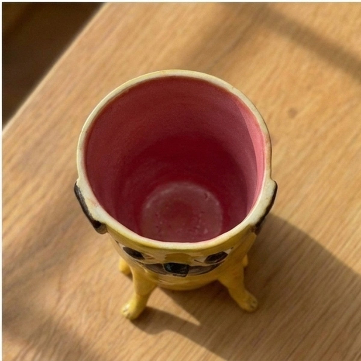 Gus the apricot pug ceramic vase, top-down view showing the pink glazed interior