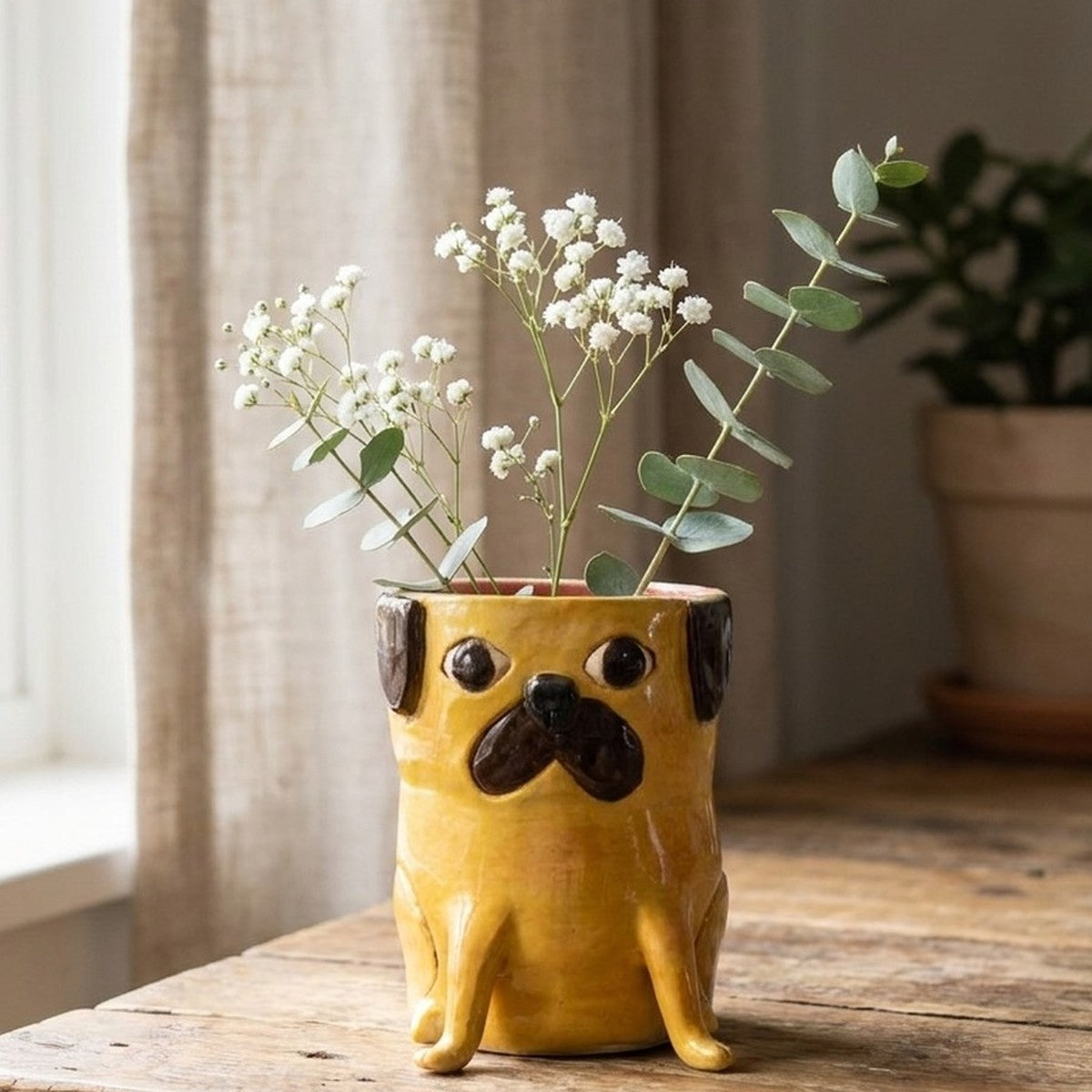 Gus the apricot pug ceramic vase with baby's breath and eucalyptus