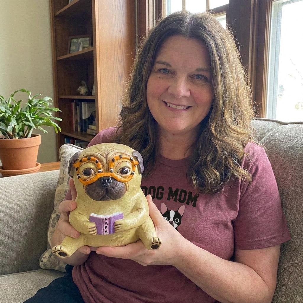 Jessie's Story founder wearing a Dog Mom shirt, holding a pug figurine