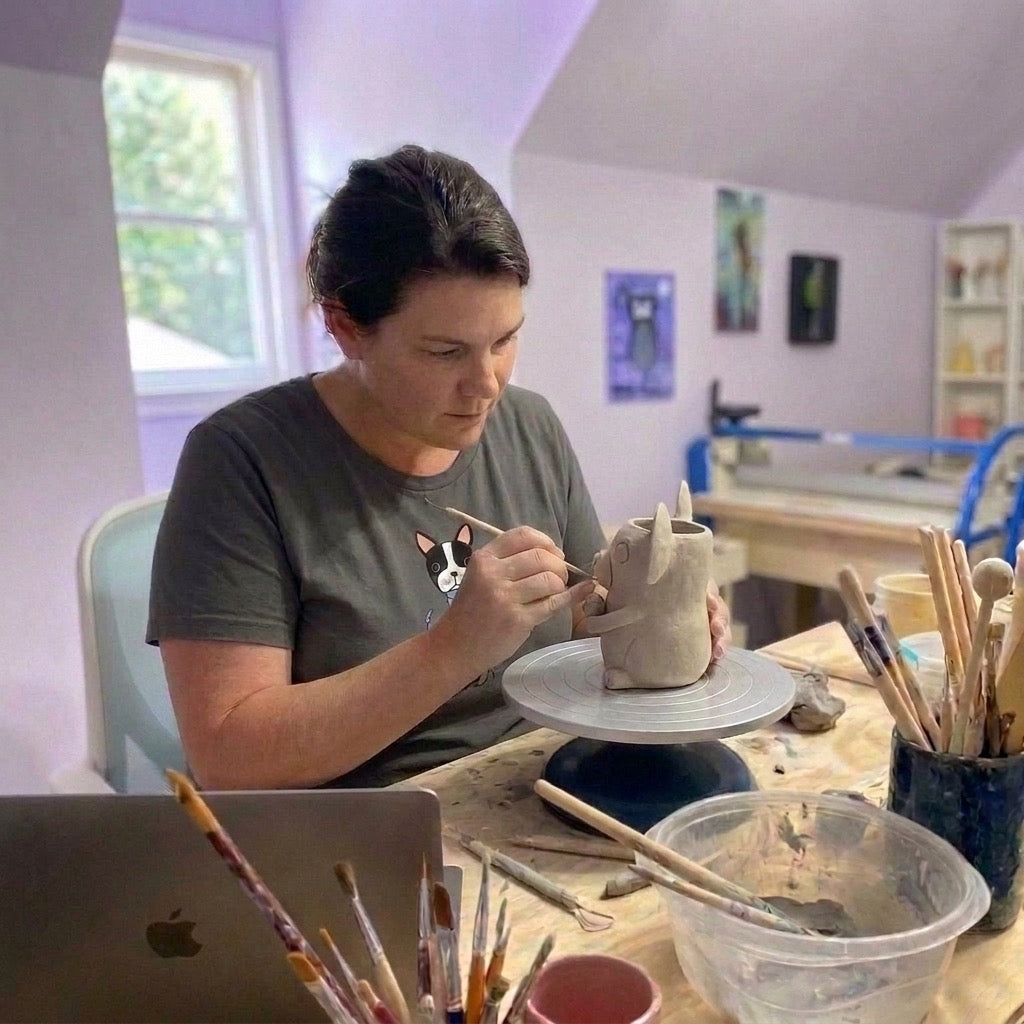 Jessie's Story founder hand-sculpting a clay dog figurine at the pottery wheel