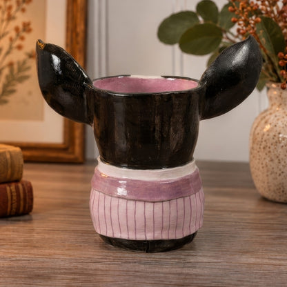 Percy, a handmade ceramic Boston Terrier vase, back view showing his black ears and pink pinstripe jacket